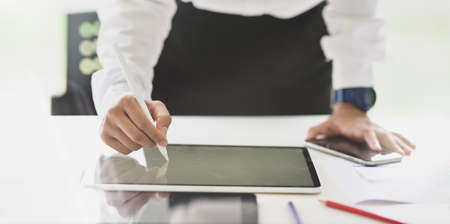 Young female designer drawing a sketch on tablet in modern workplace