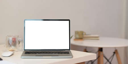 Minimal home office desk with blank screen laptop in modern workspace with blurred backgroundの写真素材