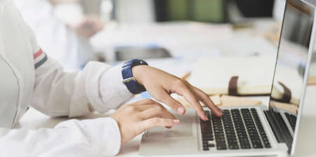 Young businesswoman working in modern office while typing on laptop computerの写真素材