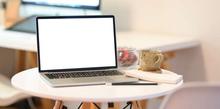 Close up minimalist shot of blank screen laptop on white table in office workspaceの写真素材
