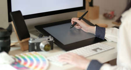 Close-up of young graphic designer drawing on tabled in creative studioの写真素材