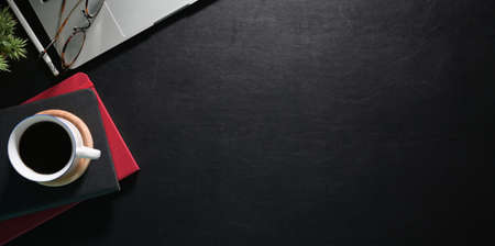 Modern office work space with laptop and office supplies, dark backgroundの写真素材