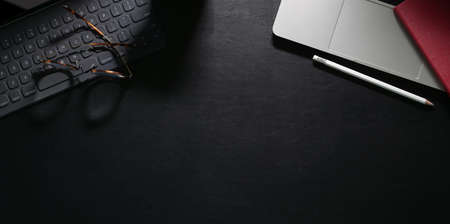 Office workspace with laptop on the modern black leather background