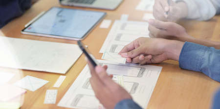 Close-up view of Young UI graphic designers discussing their application project