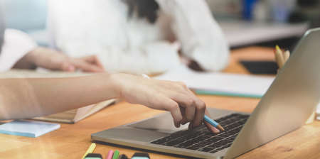 Close-up of young female collages student working on their new topics while using laptop with...