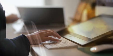 Close up of female hands typing on keyboard with blurred backgroundの写真素材