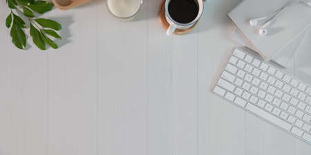 Overhead short of freelancer's minimal work space with office supplies on white wooden tableの写真素材