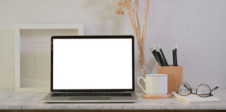 Designer's creative studio with blank screen laptop on table with copy spaceの写真素材