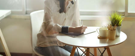 Female designer working with tablet at her desk at homeの写真素材