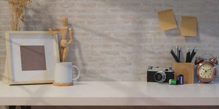 Creative photographer workplace with mock up frame, copy space and brick backgroundの写真素材
