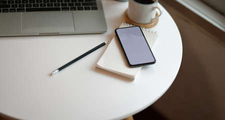 Minimal freelancer's workplace with copy space and blank screen smartphoneの写真素材