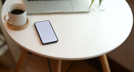 Stylish workspace with blank screen smartphone on white wooden table with office suppliesの写真素材