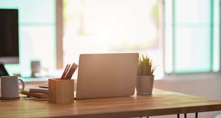 Freelancer's work space with laptop computer, office supplies and decorations in relaxing atmosphereの写真素材