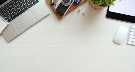 Professional photographer's desk with laptop computer, office supplies and copy space with white backgroundの写真素材