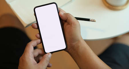 Close-up view of blank screen smartphone in freelancer's modern workplaceの写真素材