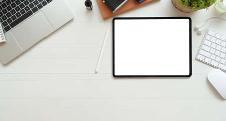 Photographer's workplace with blank screen tablet on white wooden desk, top view with copy space