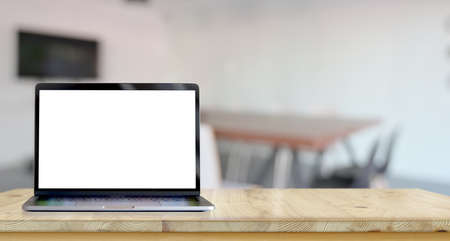 Open blank screen laptop on wooden table with blurred backgroundの写真素材