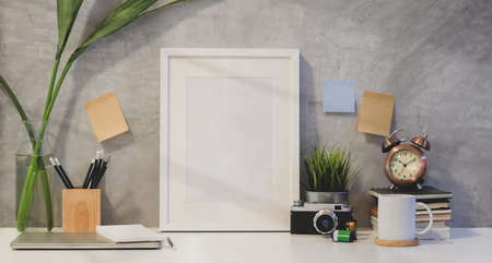 Mock up frame and copy space with office supplies in photographer's room with loft wall style...