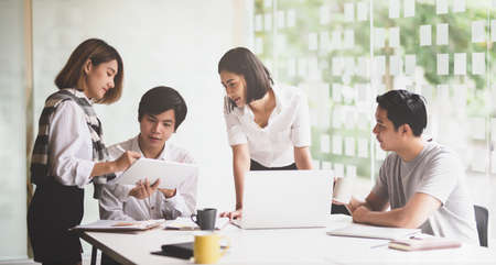 A group of young startup team brainstorming their plan for the upcoming startup projectの写真素材