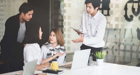 Young startup team briefing their plan before the next meeting in modern office styleの写真素材