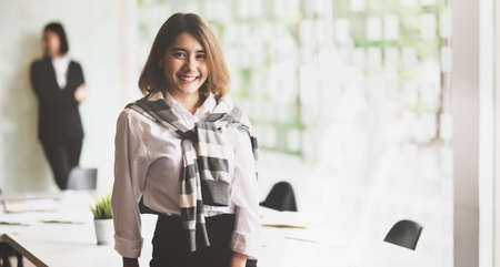Young beautiful businesswoman confidently smiling in front of meeting room for her success project