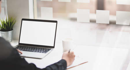 Professional businessman summarising his idea for new startup project with blank screen laptopの写真素材