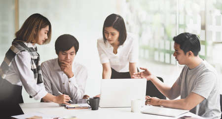 Motivated startup team consulting their startup plan together in meeting roomの写真素材