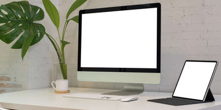 Modern workplace with with blank screen laptop computer and tabletの写真素材