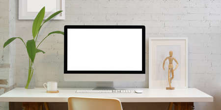 Blank screen desktop computer in minimal style office with office suppliesの写真素材