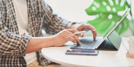 Close-up of male freelancer working on his project while typing on keyboardの写真素材