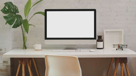 Workspace and mock up computer office on white wooden table and brick wall.の写真素材