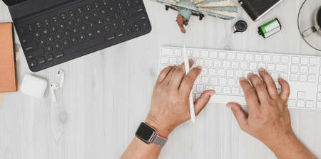 Overhead shot of man typing on keyboard in minimal style officeの写真素材