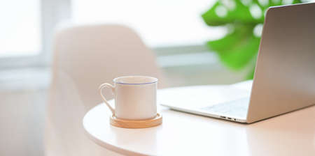 Minimal comfortable workplace with a cup of coffee and laptop computerの写真素材