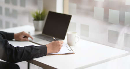 Motivated business man focusing on his project while using laptopの写真素材