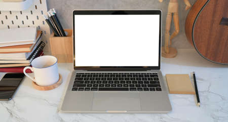 Freelancer's comfortable work place with blank screen laptop with decorations and grey wallの写真素材