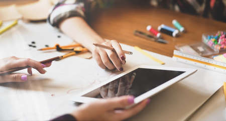 Successful young designer presenting her ideas to coworkers with tabletの写真素材