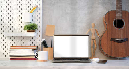 Trendy designer work place with open blank screen laptop with decorations and office suppliesの写真素材