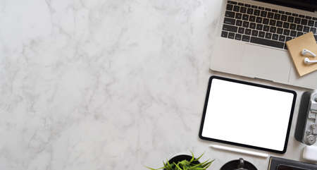 Stylish photographer's work place with copy space and blank screen tablet, top view with marble desk backgroundの写真素材