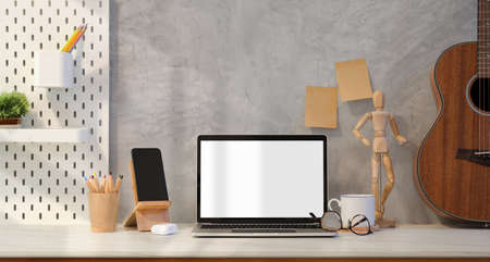 Loft style workplace with blank screen laptop and decorations on marble table and grey backgroundの写真素材