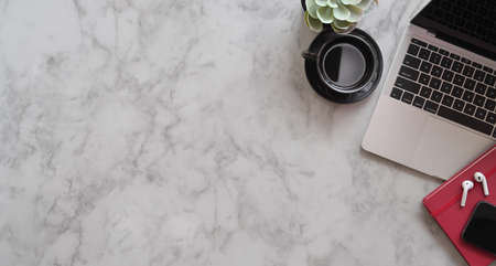 Trendy workplace with copy space and office supplies, top view with marble desk backgroundの写真素材