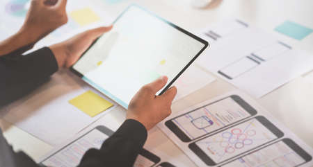 UI designer discussing on interface project while using tabletの写真素材