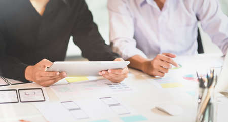 Professional UI UX designer team picking up the ideas about smartphone applications while using tabletの写真素材