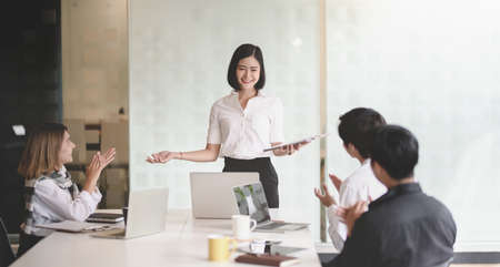 Young passionate businesswoman explaining her idea to her coworkers in the meeting roomの写真素材