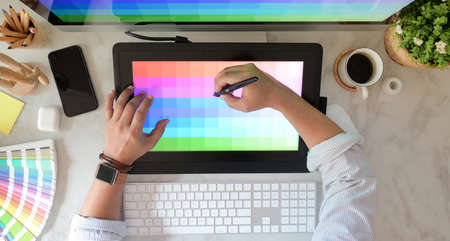 Young male graphic designer working on colour selection with colour swatchesの写真素材