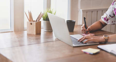 Businesswoman working on upcoming project with laptop in comfortable officeの写真素材