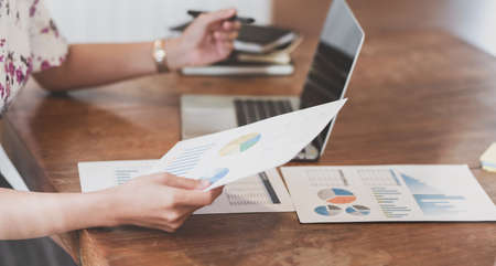 Hardworking young businesswoman analysing her strategy on marketing plan with charts and graphsの写真素材
