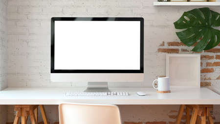Blank screen desktop computer in minimal office room with decorations and copy spaceの写真素材