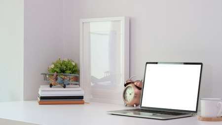 Modern workplace with blank screen laptop with office supplies in white wall backgroundの写真素材