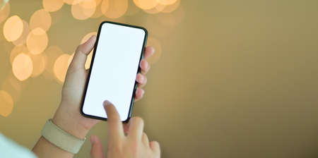 Close-up view of young girl holding blank screen smartphone with blurred backgroundの写真素材