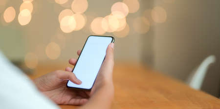 Close-up view of people holding blank screen smartphone with blurred backgroundの写真素材